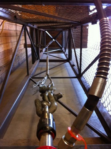A metal cage-like structure with a chain and mechanical components inside