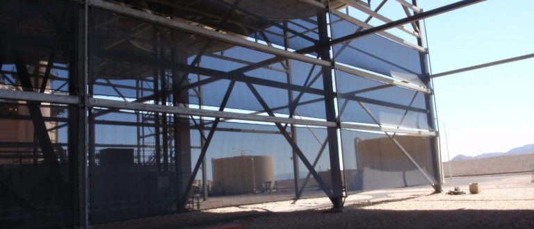 A large industrial structure with metal framework and blue mesh panels