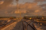 Railway tracks crisscross under a dramatic, golden-lit cloudy sky